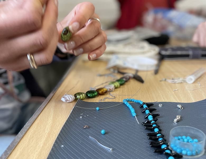 Vicky mends beaded jewellery at our eco cafe